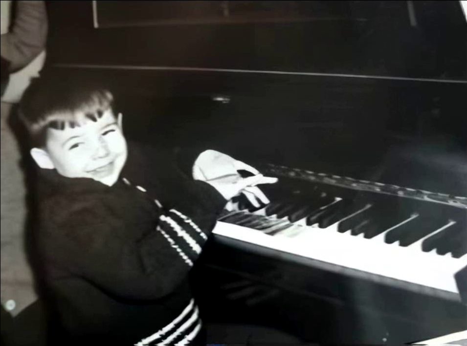 Daniel de chico, sonriendo sentado al piano